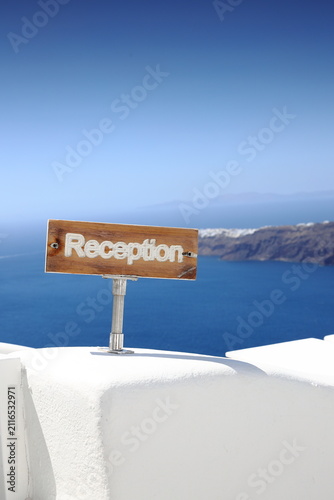 Rustic welcome sign with the ocean in the background, in Santorini. Greece