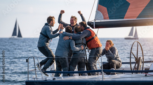 Team of sailors celebrating victory on a yacht in the ocean  