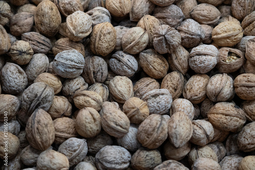 Walnut nuts in shell close-up texture background at market