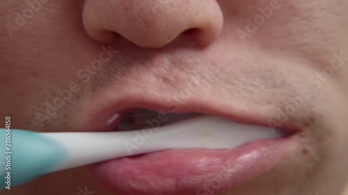 Man brushing teeth with electric toothbrush for oral hygiene