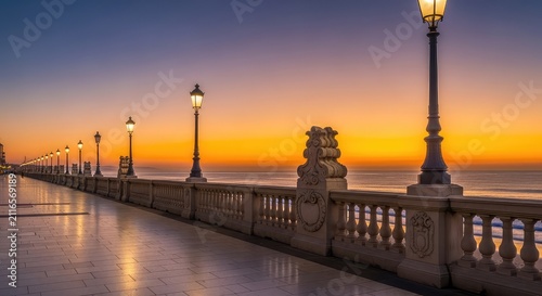 Panoramic view of a coastal promenade during sunset with classic architecture, stone balustrades, street lamps, and a colorful golden sky, coast, heritage, building
