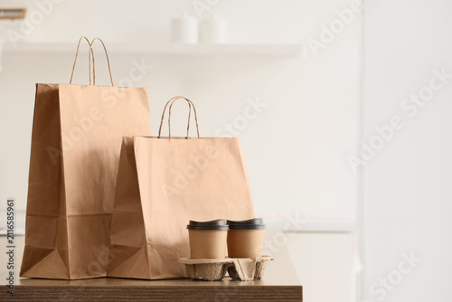 Canvastavla Paper bags with coffee cups on table in kitchen