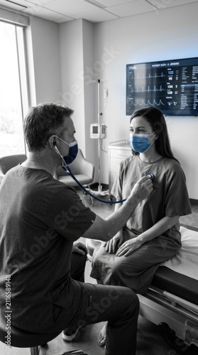 Doctor Examining Patient Wearing Face Masks In Modern Medical Clinic