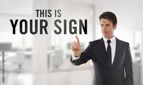 Professional businessman in a dark suit points at the words