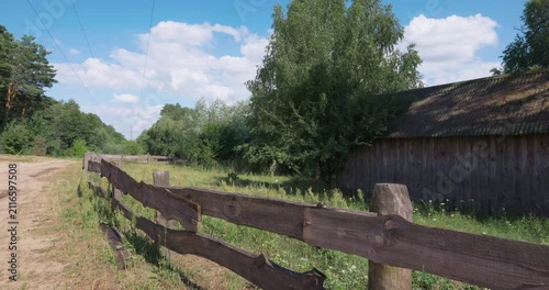 Perspective view at old wooden barn behind a rustic fence in the countryside