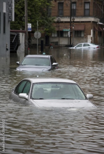flooded cars on the street, water above the hood, no car logo visible, flooding in the city