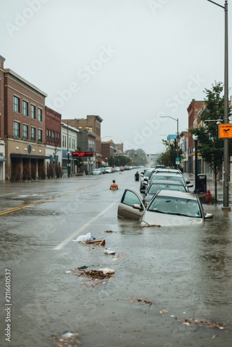 flooded cars on the street, water above the hood, no car logo visible, flooding in the city