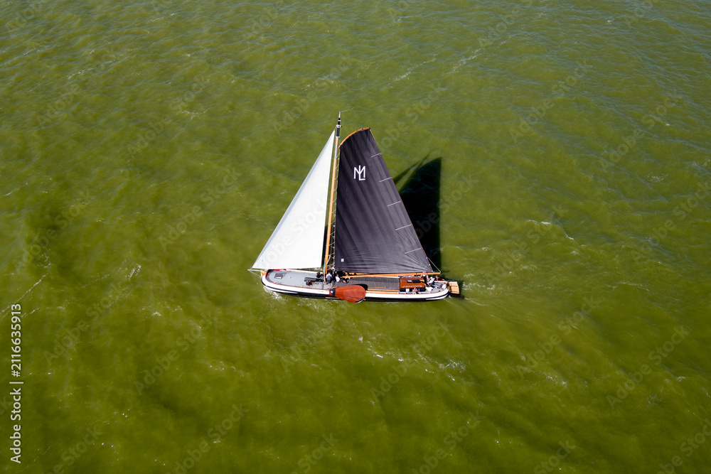 Fototapeta premium STAVOREN, THE NETHERLANDS AUGUST 12, 2023: Traditional Skutsjes Compete During the Annual SKS Skutsjesilen Sailing Championship on the IJsselmeer