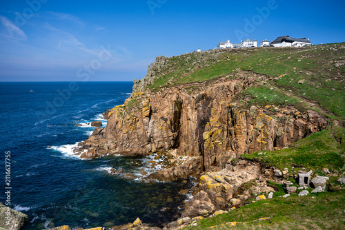 Steep cliffs above the Atlantic Ocean at the edge of Southern England, with white buildings on the peak