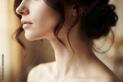 Profile View Close-Up of Elegant Young Woman with Updo Haircut and Natural Makeup