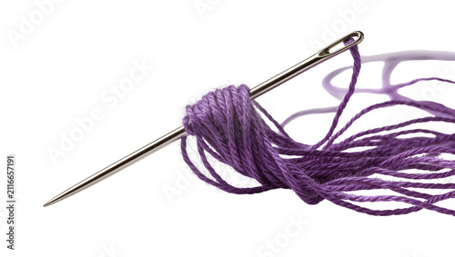 Isolated sharp metallic needle with vibrant purple embroidery thread neatly wrapped around it.