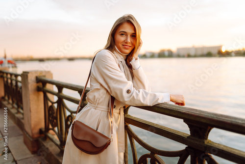 Photography Beautiful woman poses on city embankment at sunset