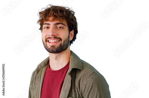 Canvastavla Happy young man with curly hair and beard smiling for portrait, standing against