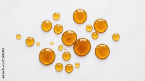 Closeup of Amber Liquid Droplets on a White Background.