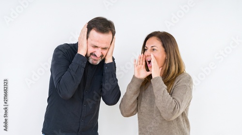 A man covers his ears as a woman shouts at him, representing conflict and disagreement.