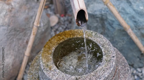 Relaxing water drop dripping from bamboo pipe close up