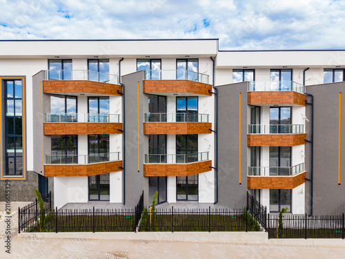Photography Modern apartment building with wooden balconies in a residential area under a cl
