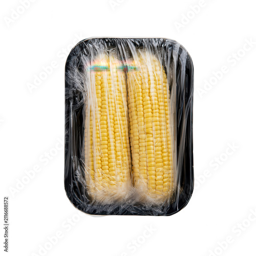 Two shucked corn ears in plastic wrap. Fresh yellow maize cobs isolated on white background.
