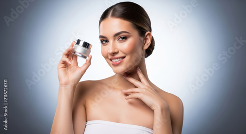 Smiling woman holding jar of skincare cream, posing with smooth skin and elegant hairstyle, product showcasing beauty treatment.