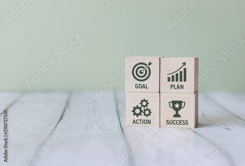 Goal Plan Action Success Concept on Wooden Blocks with Business Strategy Icons.