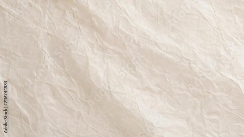 High resolution close-up of crumpled beige paper texture. This versatile surface features natural creases, folds, and delicate shadows, ideal for organic stationery mockups, vintage art overlays