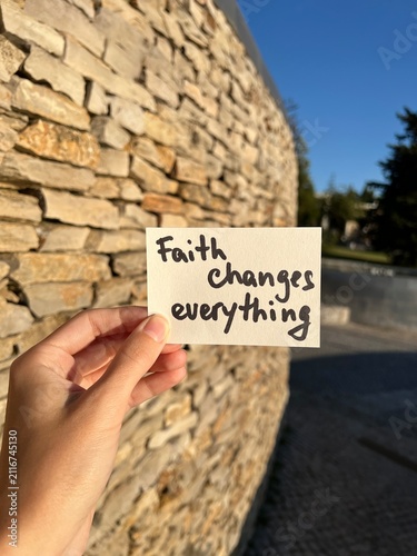 Christian lettering in the hand - Faith changes everything, vertical card with religion concept