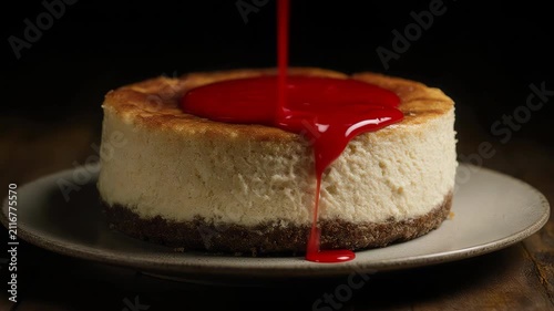  classic cheesecake slice as a thin stream of strawberry sauce slowly flows across the surface