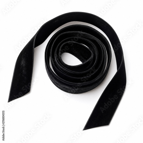 Overhead view of a black velvet ribbon coiled into a loose spiral with its cut ends splayed outward, on pure white. Generative AI photorealistic Halloween studio image isolated on white.