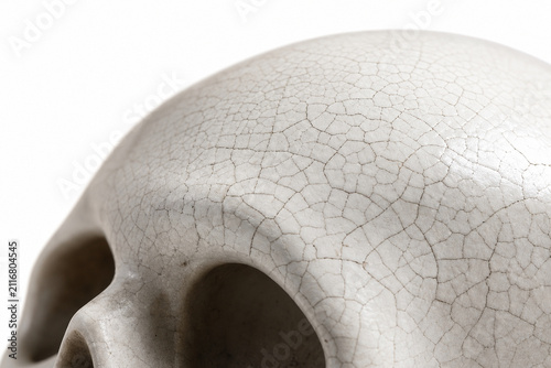 Macro detail of fine crackle glaze spreading across the temple of a pale ceramic skull, isolated on pure white. Generative AI photorealistic Halloween studio image isolated on white.