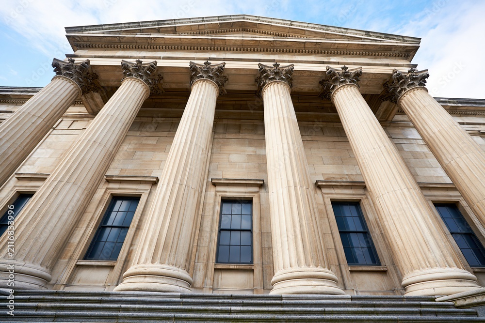 Obraz premium Grand Classical Architecture with Ionic Columns and Tall Windows Under a Clear Sky