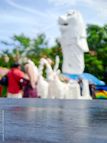 Obraz na płótnie Blurred view of Merlion statue in Singapore with tourists and greenery
