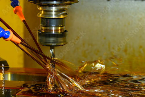 CNC milling machine performing hole drilling process using canned cycle with oil coolant fluid