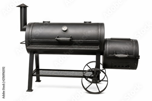 Classic black charcoal barbecue smoker grill on wheels ready for outdoor cooking. Heavy-duty steel BBQ smoker with side table and chimney for profe...
