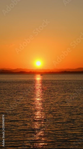 nature sky breathtaking golden sunset over a calm ocean, with the entire sky and water bathed in brilliant shades of yellow and orange. Streaky clouds enhance the dramatic display	