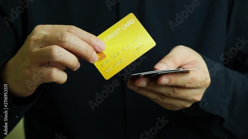 Close up of hand human holding multiple color credit cards, choosing a red card for payment, concept of consumerism, financial management, debt and cashless society and saving money	