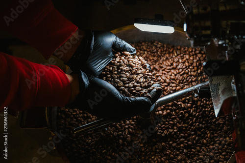 Foto A coffee roaster puts coffee beans into a roaster machine.