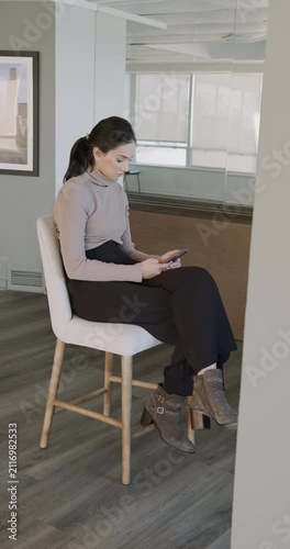Young professional woman using smartphone in modern office