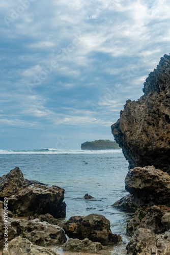 Rocky Coastal Cliff Overlooking Calm Ocean Waters Under Dramatic Cloudy Sky
