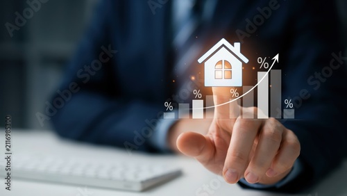 Businessman pointing at growing real estate market house icon and interest rates