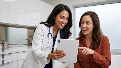 Compassionate female doctor discussing digital health records on a tablet with a patient in a modern clinic.