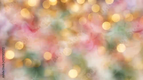 Soft abstract background with golden bokeh lights and pastel colors.