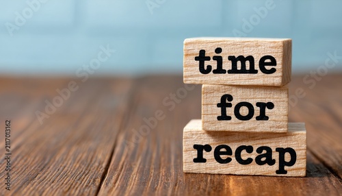 Wooden blocks spelling Time for Recap on a dark wooden table. Educational concept for business training.