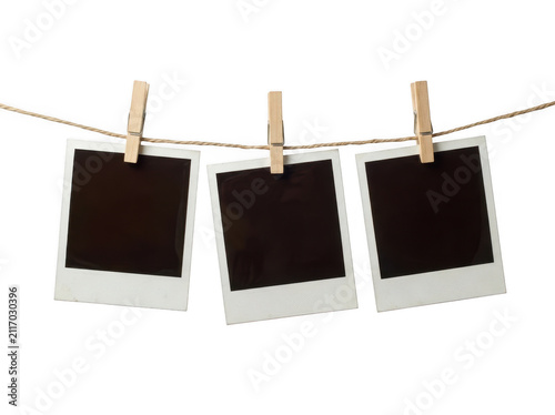 Three blank instant photo frames hanging on a rope with wooden clips