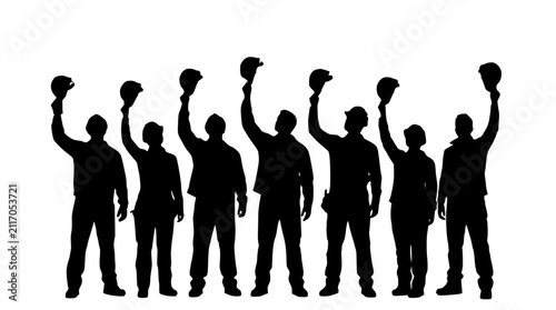Fotografie Group of workers holding up hard hats in silhouette