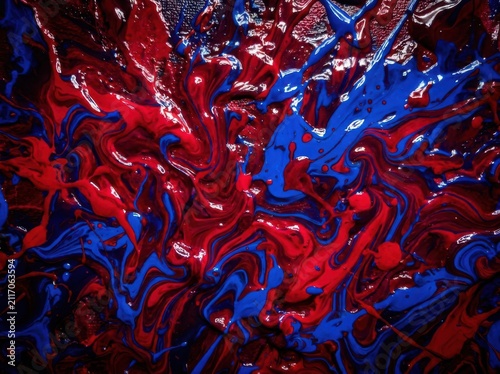 Vibrant red and blue paint splatters in dynamic abstract motion during energetic creation with dramatic lighting and texture