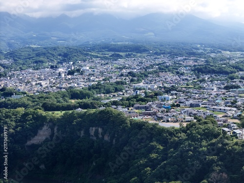 Mountain village sprawls below, green hills frame the view