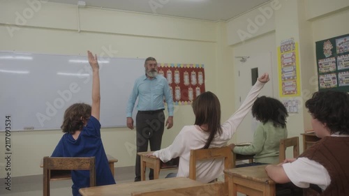 The teacher is teaching young children in a class at school.