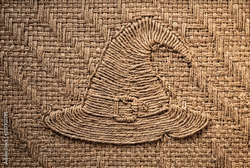 Handcrafted Witch's Hat from Coiled Jute Rope on a Textured Burlap Surface, Evoking Rustic Halloween Charm and Natural Craftsmanship