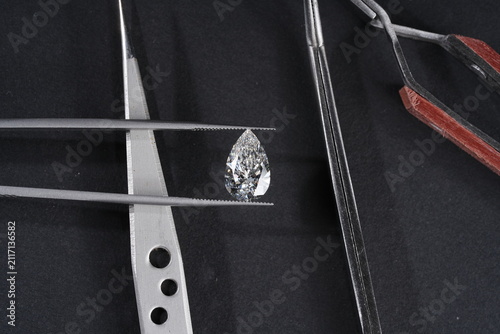 Картината върху платно Exquisite pear-shaped diamond with tweezers, showcasing rare luxury and investme