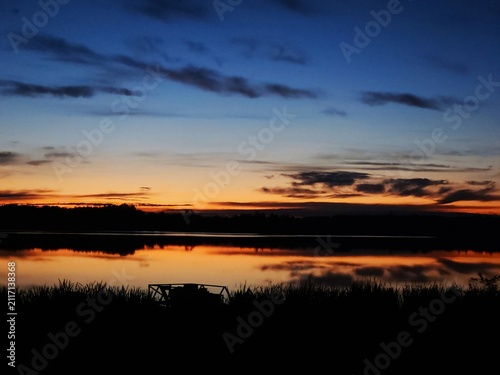Bild auf Leinwand Lake Sunset Landscape with Deep Blue Twilight Sky and Orange Water Reflection
